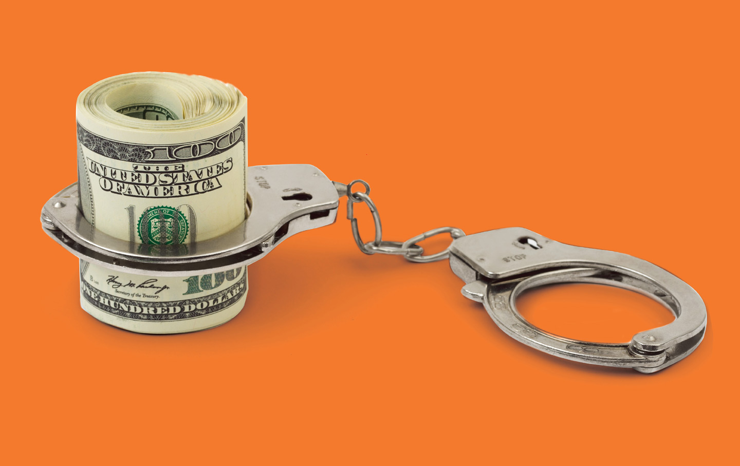 Handcuffs around a roll of money and an orange background